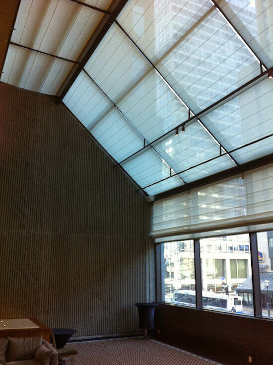 Hotel sunscreen roller shades on angled hotel atrium